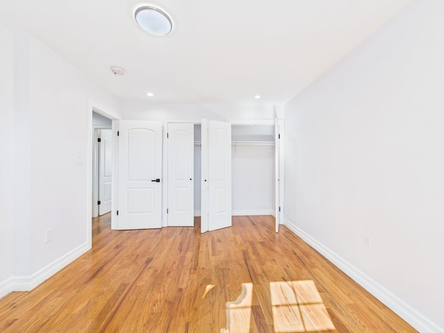 unfurnished bedroom with recessed lighting, light wood-type flooring, and baseboards