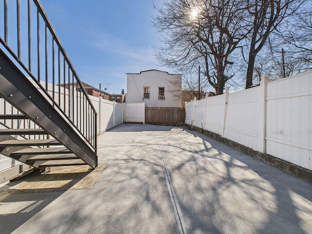 view of patio with stairway and a fenced backyard