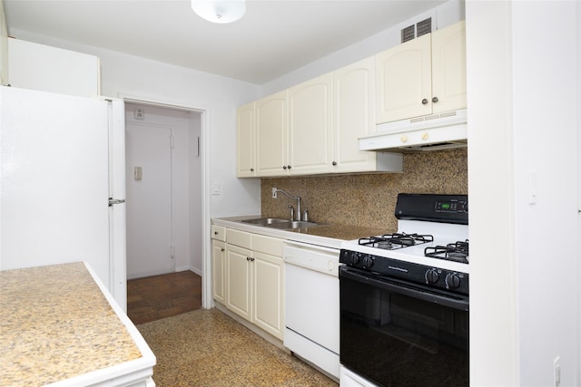 kitchen with under cabinet range hood, light countertops, decorative backsplash, white appliances, and a sink