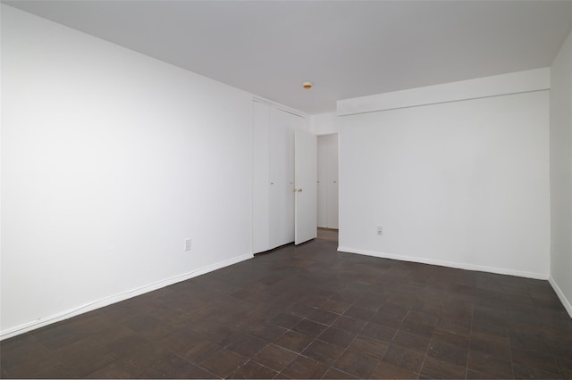 unfurnished room with baseboards