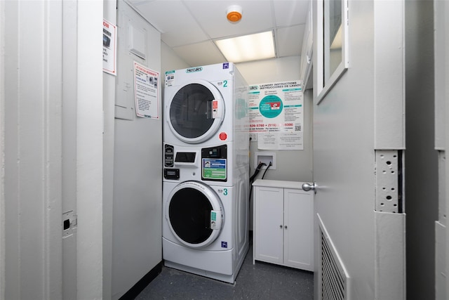 laundry area with cabinet space and stacked washing maching and dryer