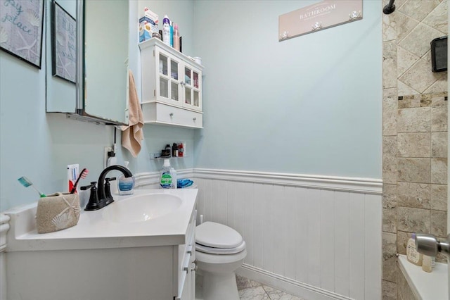 bathroom featuring vanity, a shower, wainscoting, toilet, and marble finish floor