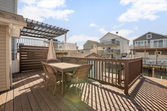 wooden deck with outdoor dining area, a residential view, and a pergola