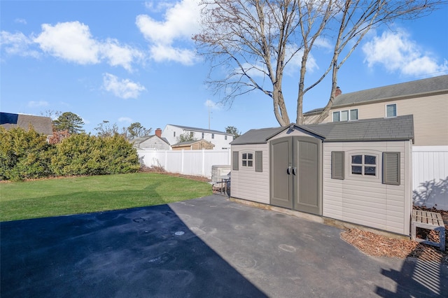 exterior space with a fenced backyard, a yard, a storage shed, an outdoor structure, and a patio area