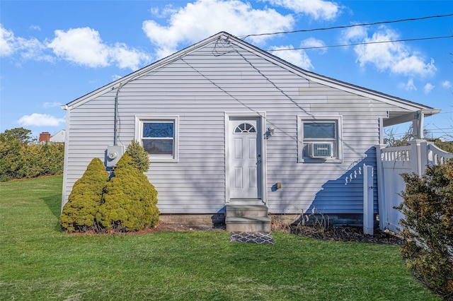 back of house with cooling unit, entry steps, and a yard