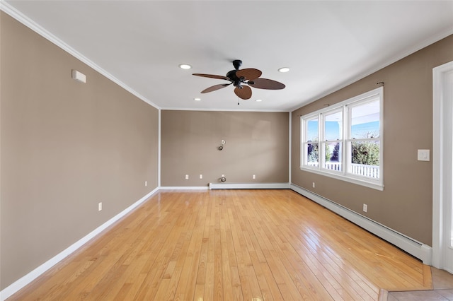 empty room with light wood-type flooring, a baseboard heating unit, baseboards, and ornamental molding