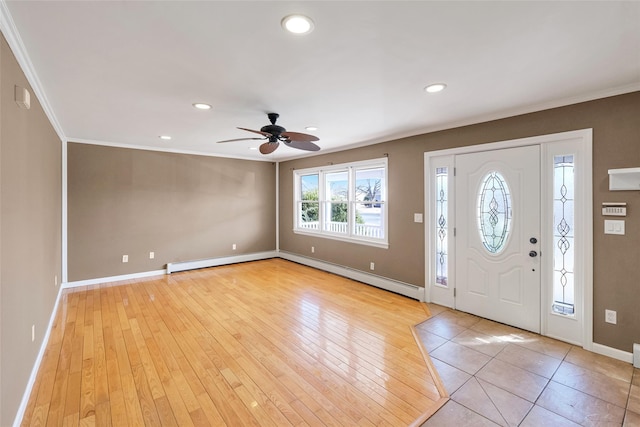 foyer with light wood-style floors, baseboards, baseboard heating, and ornamental molding