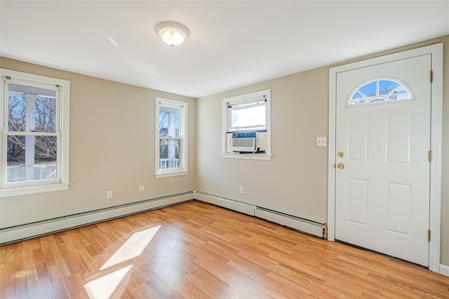 foyer with cooling unit, baseboard heating, and light wood-style flooring