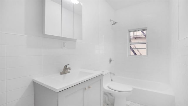 full bath featuring toilet, marble finish floor, tile walls, bathtub / shower combination, and vanity