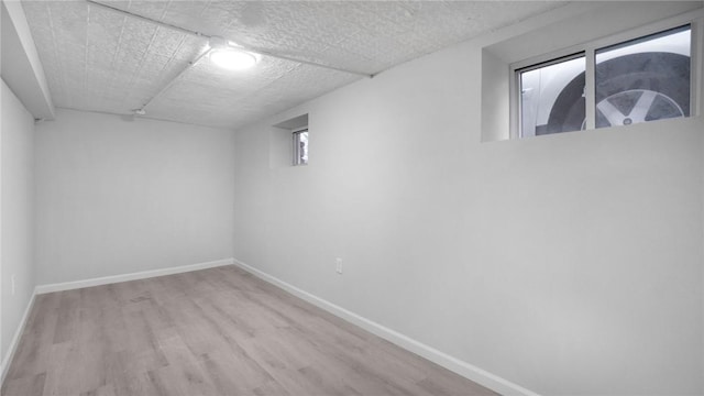 basement with baseboards and wood finished floors