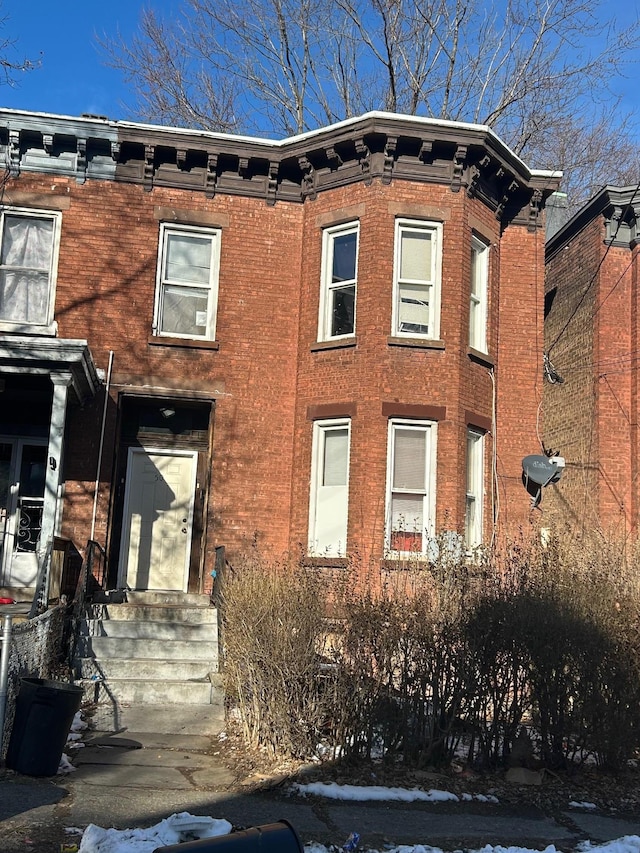 italianate-style house with entry steps and brick siding