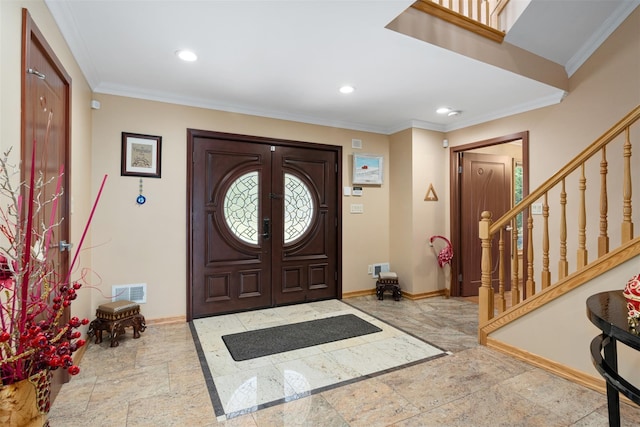 entrance foyer with stairway, visible vents, baseboards, stone tile flooring, and ornamental molding