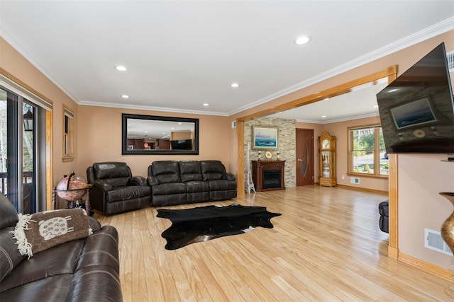 living area featuring visible vents, wood finished floors, recessed lighting, a fireplace, and crown molding