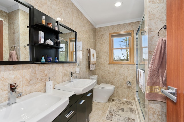 bathroom with a sink, a shower stall, and crown molding