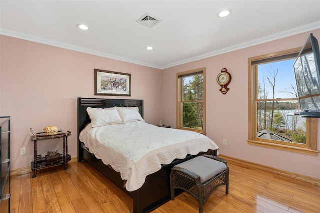 bedroom with ornamental molding, baseboards, visible vents, and light wood-type flooring