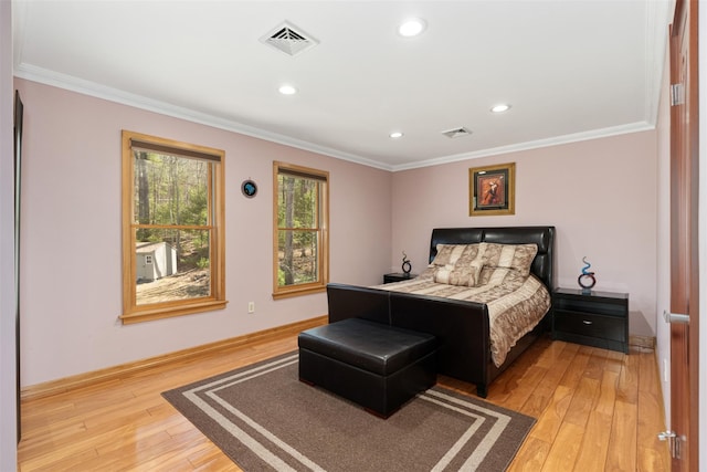 bedroom with visible vents, ornamental molding, and light wood finished floors