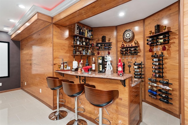 bar featuring light tile patterned floors, wooden walls, recessed lighting, and baseboards