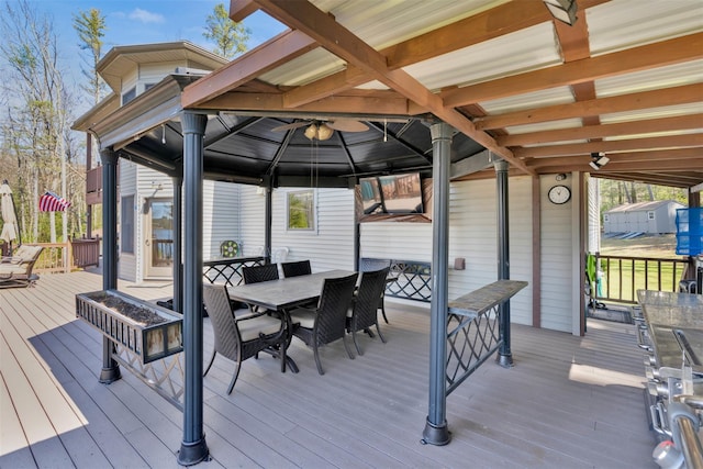 wooden deck featuring outdoor dining space and a gazebo