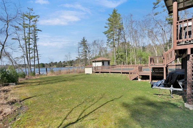 view of yard with stairs and a deck with water view