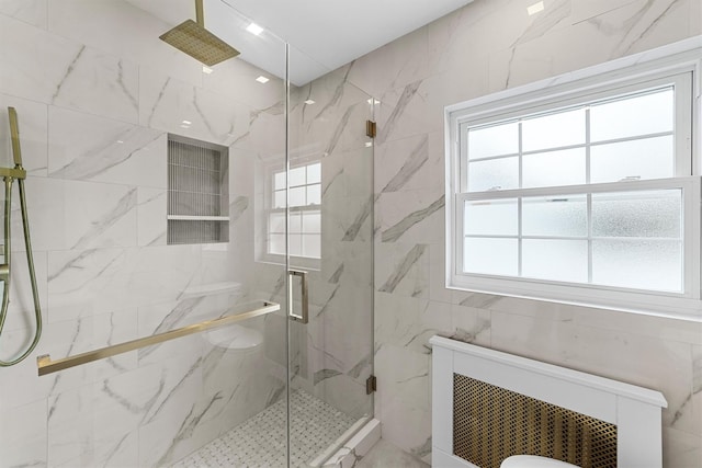 bathroom featuring a marble finish shower and tile walls