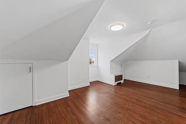 additional living space featuring lofted ceiling, wood finished floors, and baseboards