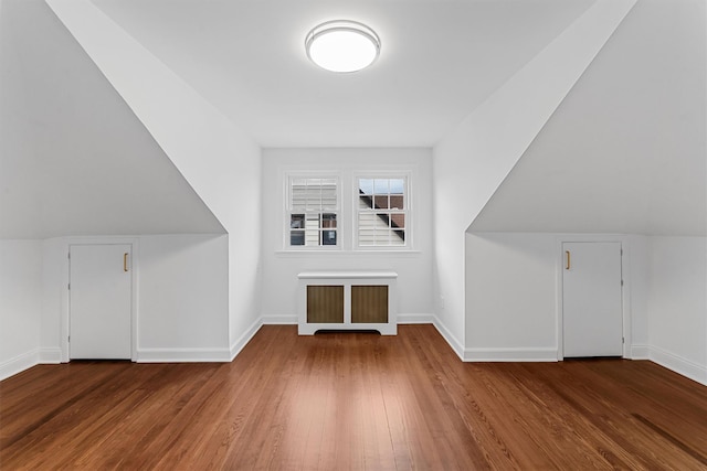 bonus room featuring baseboards, lofted ceiling, and wood finished floors