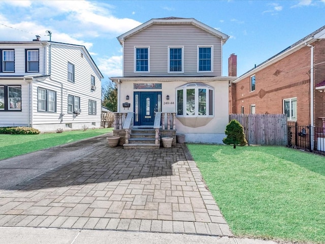 view of front of house with a front yard and fence