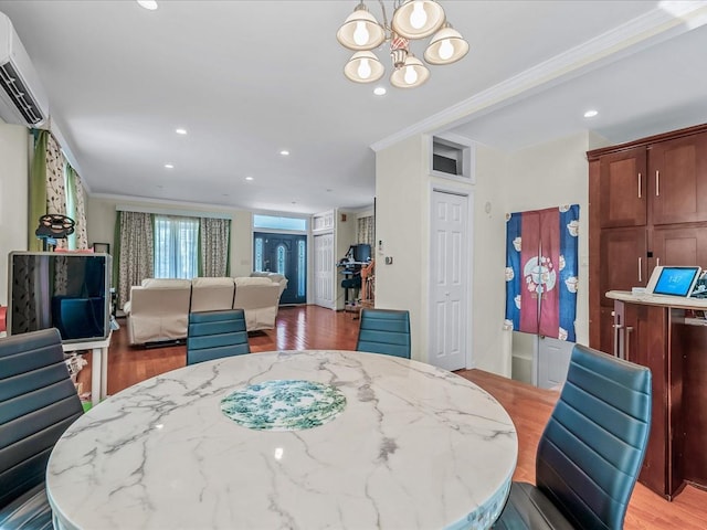 dining space with light wood finished floors, recessed lighting, crown molding, and a wall unit AC