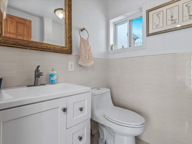 bathroom featuring tile walls, toilet, and vanity