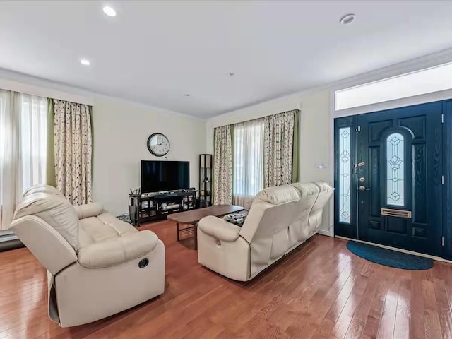 living area with recessed lighting, ornamental molding, and wood-type flooring