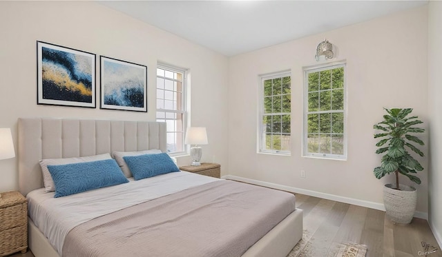 bedroom with wood finished floors and baseboards