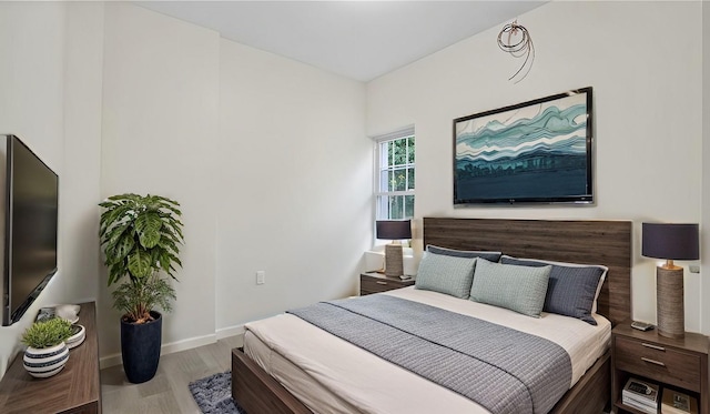 bedroom with baseboards and wood finished floors