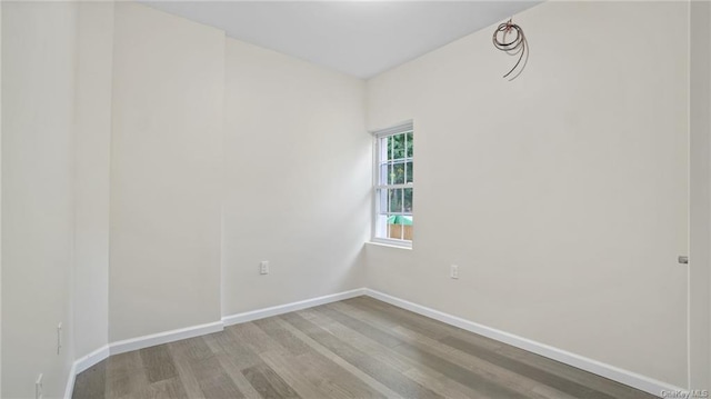 unfurnished room featuring baseboards and light wood-style floors