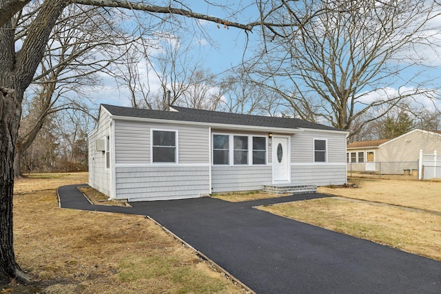 view of front of house with a front lawn, fence, and driveway