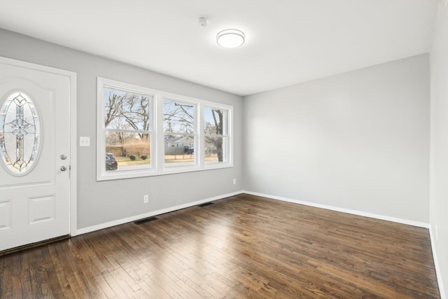 foyer entrance with visible vents, baseboards, and wood-type flooring