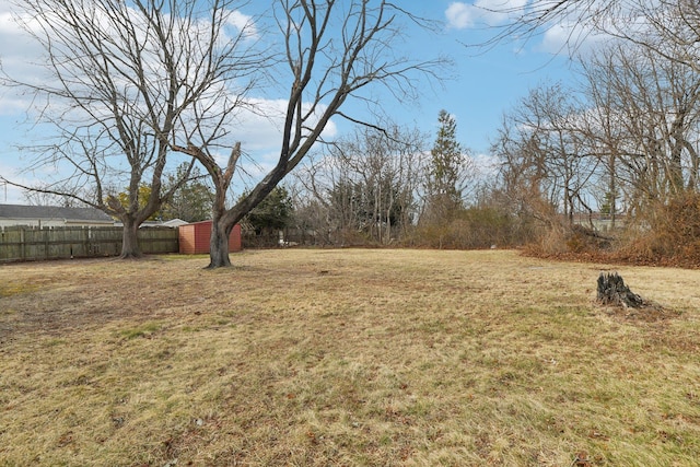 view of yard featuring an outdoor structure and fence