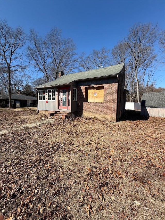 view of front of house with brick siding and a chimney