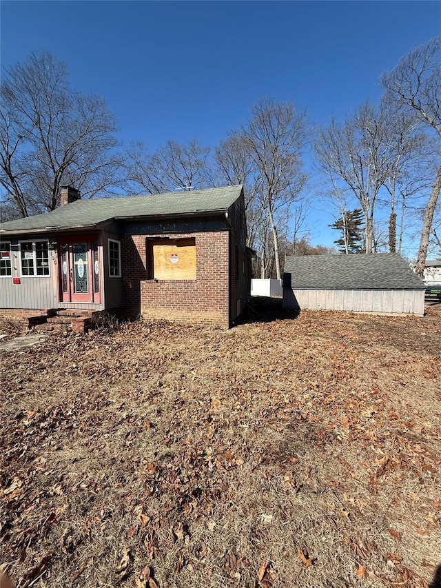 view of side of property featuring brick siding and a chimney