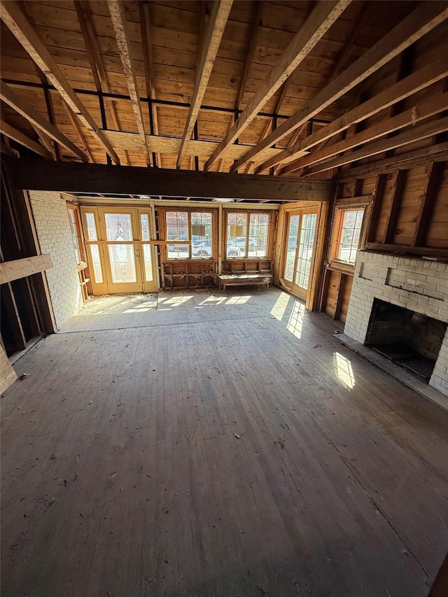 unfurnished living room featuring a fireplace, wood ceiling, lofted ceiling with beams, and hardwood / wood-style flooring