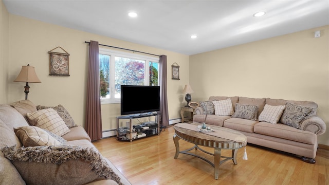 living area featuring a baseboard heating unit, light wood-style flooring, and recessed lighting