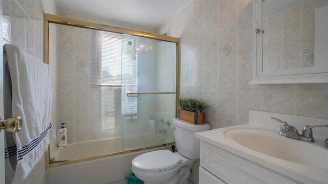 full bath featuring vanity, tile walls, toilet, and enclosed tub / shower combo