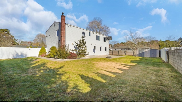 rear view of house with a storage unit, a fenced backyard, and an outdoor structure