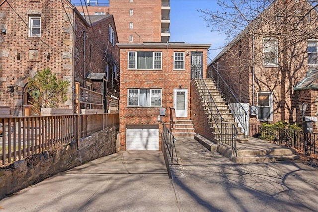 back of property with brick siding, driveway, a garage, and fence