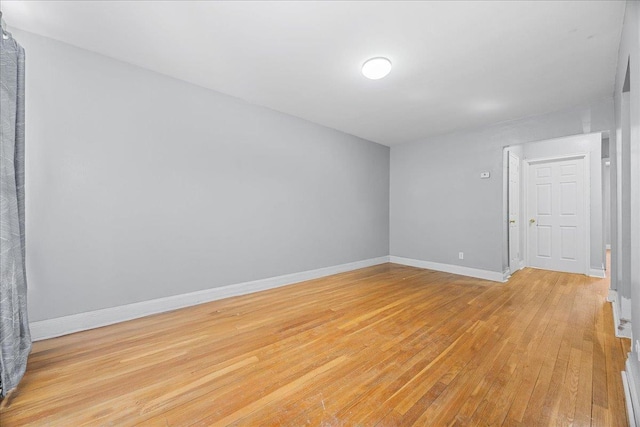 empty room with baseboards and light wood-style floors