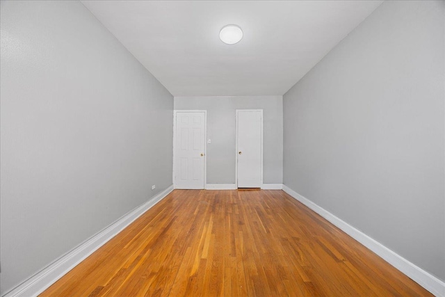 spare room with wood finished floors and baseboards