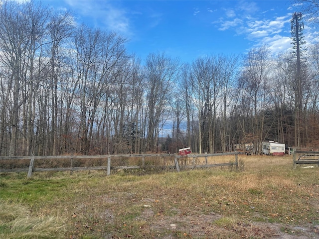 view of yard featuring fence and a view of trees