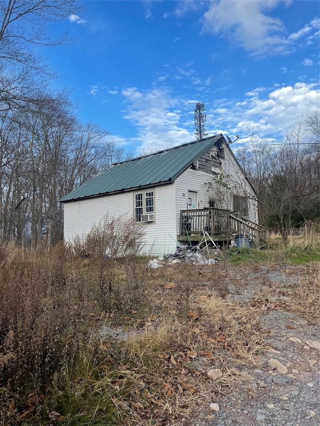 view of home's exterior with a deck and metal roof