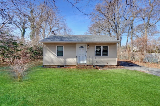 bungalow-style home featuring a shingled roof, a chimney, a front yard, and fence