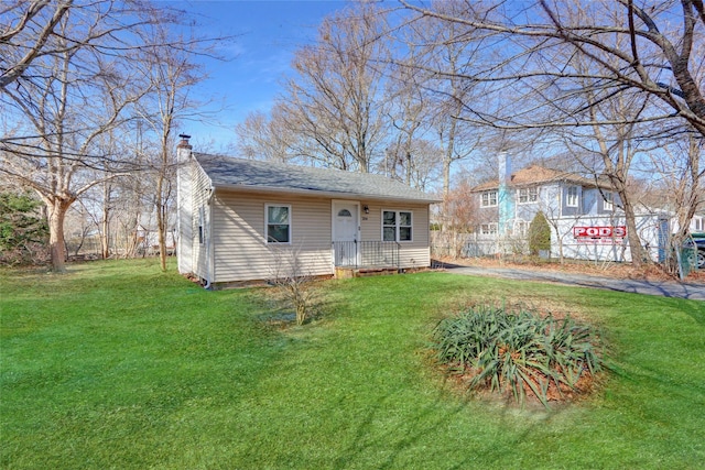 view of front of house with a chimney and a front yard