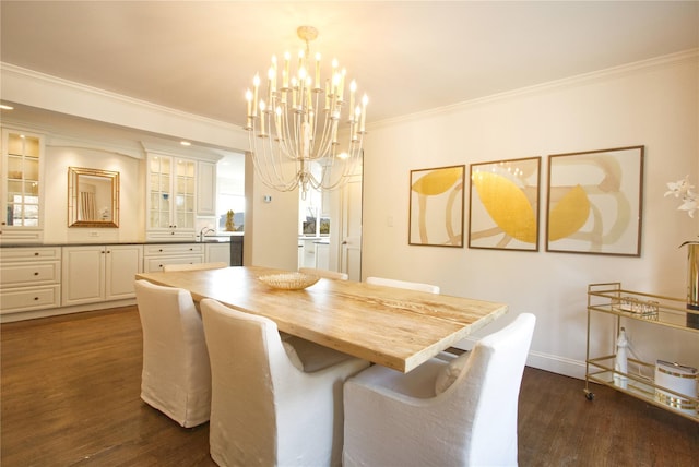 dining room featuring dark wood-type flooring, ornamental molding, baseboards, and a chandelier